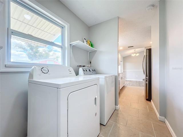 laundry area featuring a chandelier, light tile floors, washer and dryer, washer hookup, and a textured ceiling