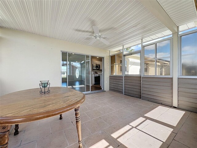 unfurnished sunroom with ceiling fan