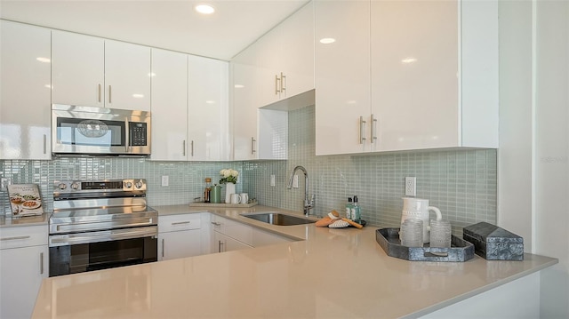 kitchen with white cabinetry, appliances with stainless steel finishes, sink, and decorative backsplash