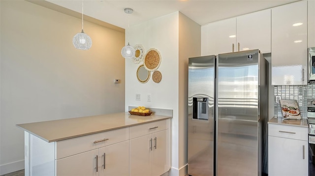 kitchen with decorative backsplash, stainless steel fridge, kitchen peninsula, pendant lighting, and white cabinets