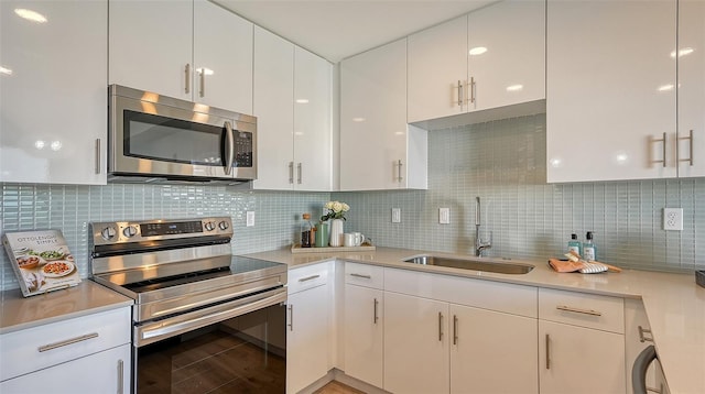 kitchen featuring light countertops, appliances with stainless steel finishes, and white cabinets