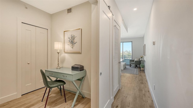 home office with light wood finished floors, baseboards, and visible vents