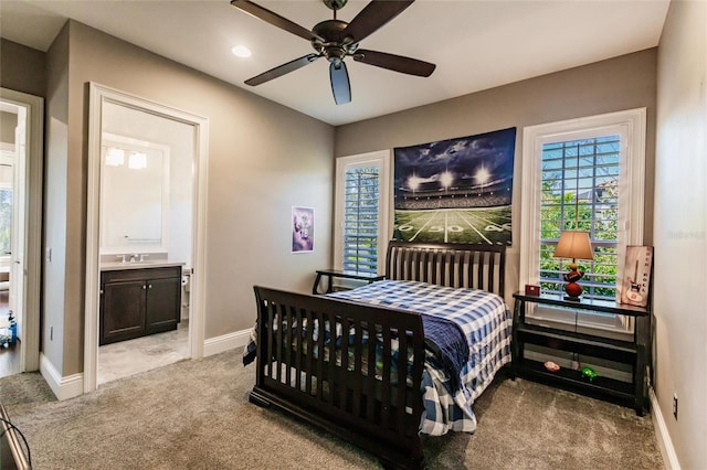 carpeted bedroom featuring ceiling fan, sink, and ensuite bath