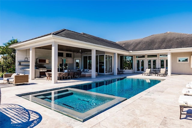 view of pool featuring outdoor lounge area, ceiling fan, exterior kitchen, grilling area, and a patio area