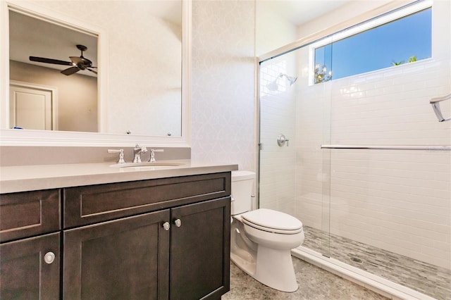 bathroom with ceiling fan, vanity, an enclosed shower, and toilet