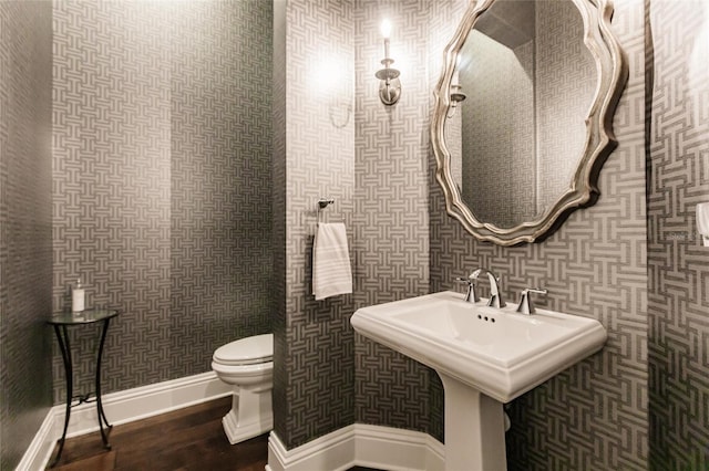 bathroom featuring sink, hardwood / wood-style floors, and toilet