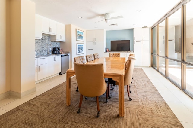 dining room featuring a ceiling fan, visible vents, a wall of windows, and light tile patterned floors