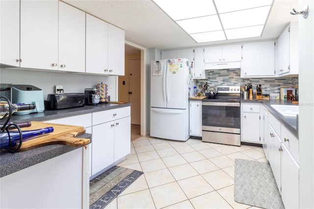 kitchen with white cabinetry, stainless steel electric range, light tile patterned flooring, and freestanding refrigerator