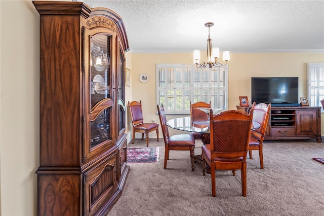 carpeted dining space featuring ornamental molding, a chandelier, and a textured ceiling