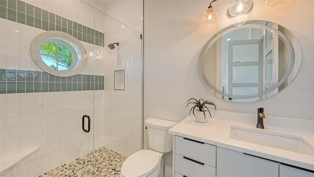 bathroom featuring vanity, toilet, and an enclosed shower