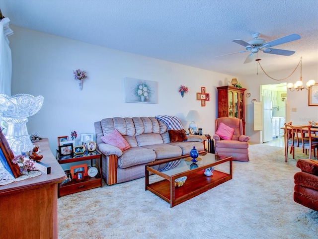 carpeted living room with ceiling fan with notable chandelier and a textured ceiling