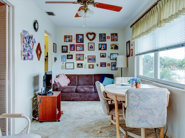 dining area with light carpet and ceiling fan