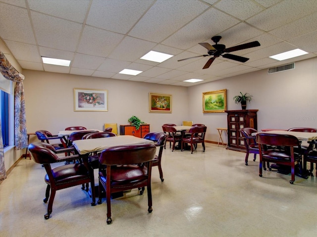 dining space featuring a drop ceiling and ceiling fan