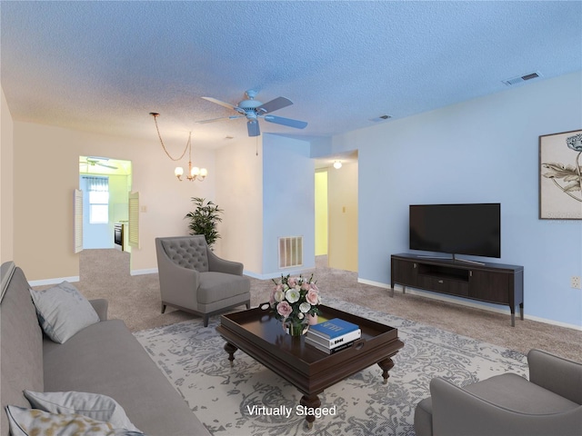 carpeted living room with ceiling fan with notable chandelier and a textured ceiling