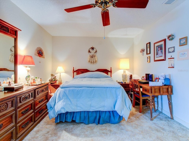 carpeted bedroom featuring ceiling fan and a textured ceiling