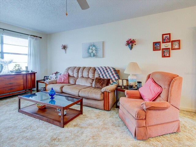 living room with light carpet, a textured ceiling, and ceiling fan