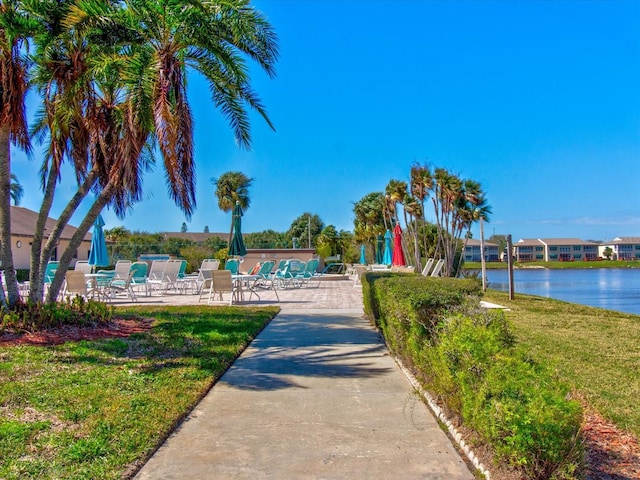 surrounding community featuring a lawn and a water view