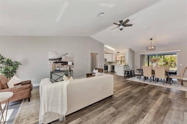 living room featuring vaulted ceiling, ceiling fan, and dark wood-type flooring