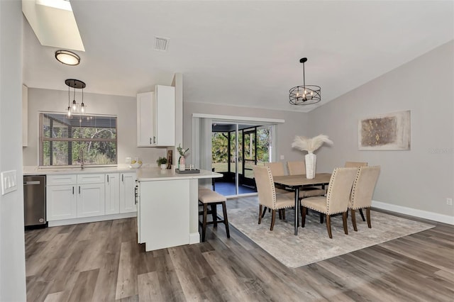 kitchen featuring light hardwood / wood-style floors, hanging light fixtures, a notable chandelier, and white cabinetry