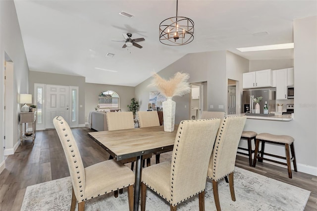 dining area with lofted ceiling, dark hardwood / wood-style floors, and ceiling fan with notable chandelier