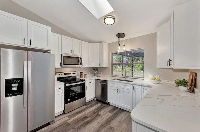 kitchen featuring light stone countertops, light hardwood / wood-style floors, sink, stainless steel appliances, and white cabinets