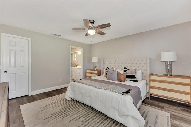 bedroom with ensuite bath, ceiling fan, and dark hardwood / wood-style flooring