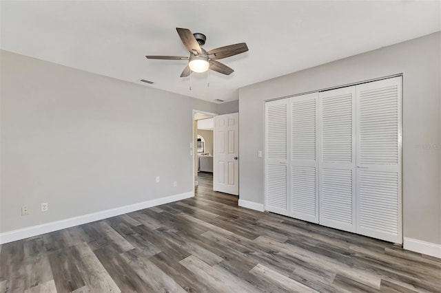 unfurnished bedroom with a closet, ceiling fan, and dark wood-type flooring