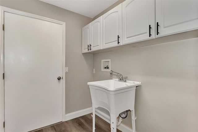 laundry room featuring washer hookup, cabinets, and dark wood-type flooring