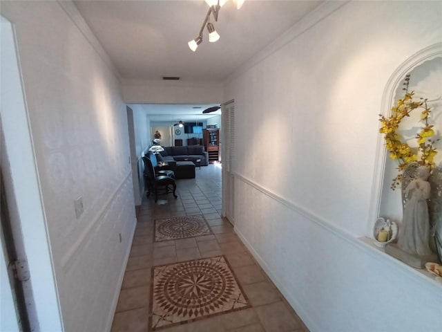 hallway with crown molding and light tile patterned flooring