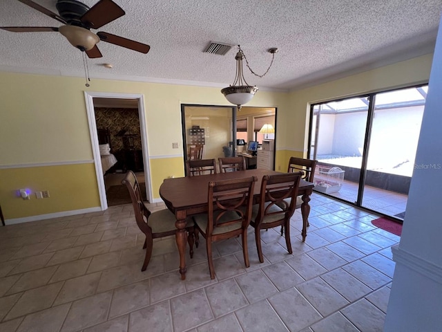 dining room featuring light tile patterned floors, a textured ceiling, ceiling fan, and ornamental molding