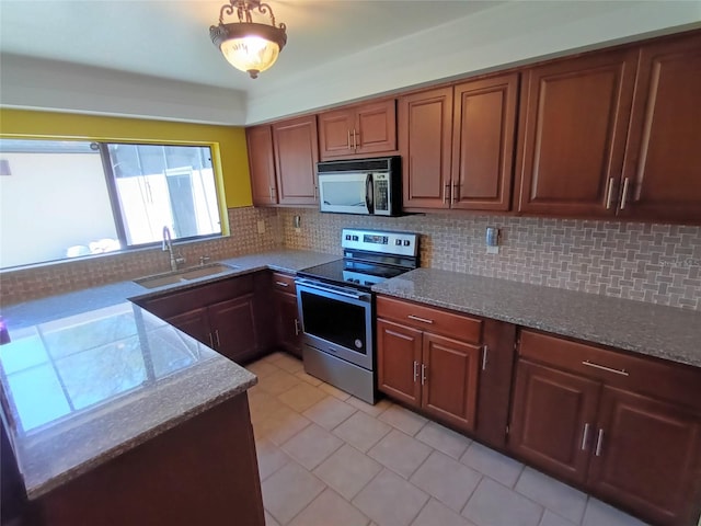 kitchen featuring decorative light fixtures, backsplash, stainless steel appliances, and sink