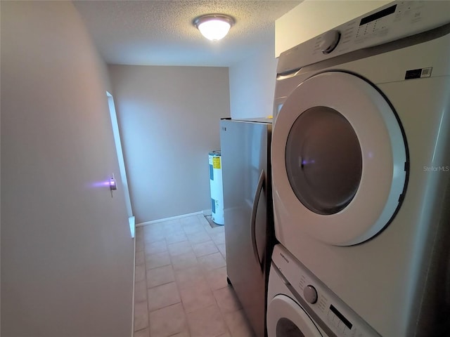 laundry room with a textured ceiling, light tile patterned flooring, and stacked washer / drying machine