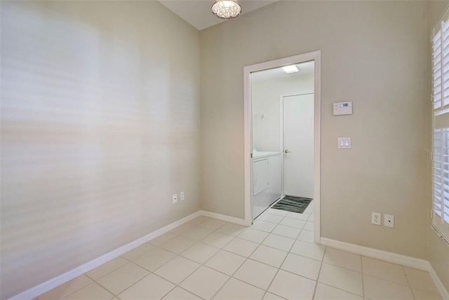 empty room featuring an inviting chandelier and light tile flooring