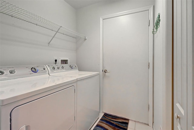 clothes washing area featuring washer hookup, washer and dryer, and light tile floors