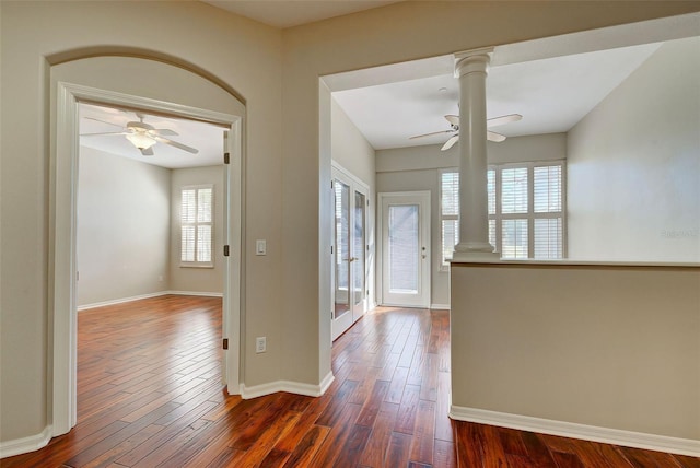 entryway with ceiling fan, dark wood-type flooring, and ornate columns