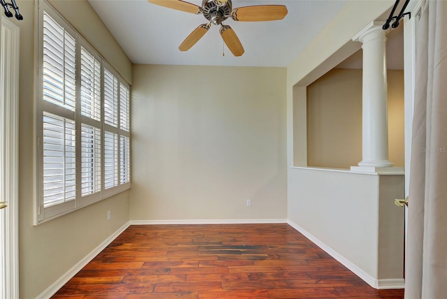 spare room featuring dark hardwood / wood-style floors, decorative columns, ceiling fan, and a wealth of natural light