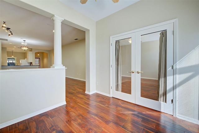 spare room featuring french doors, ceiling fan, dark wood-type flooring, and ornate columns