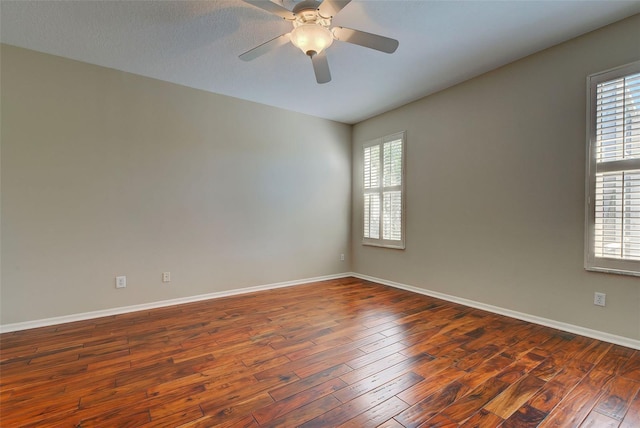 empty room featuring ceiling fan and dark hardwood / wood-style flooring