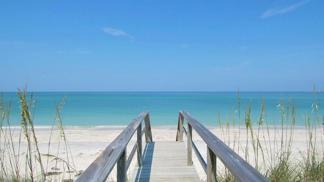 dock area with a water view and a beach view