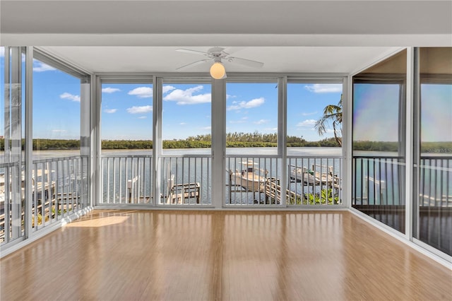 unfurnished sunroom featuring a water view and ceiling fan