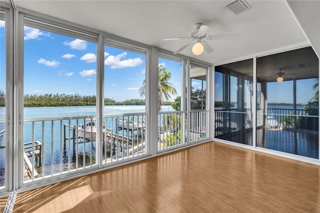 unfurnished sunroom featuring a water view and ceiling fan