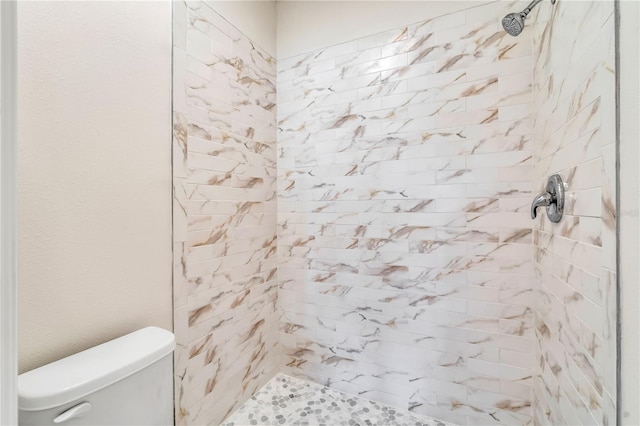 bathroom with toilet and tiled shower