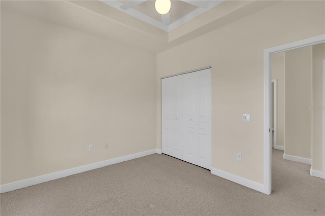 unfurnished bedroom featuring a closet, ceiling fan, and light colored carpet