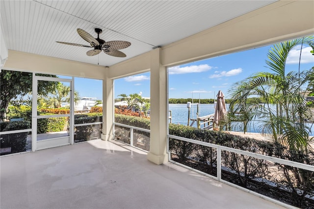 unfurnished sunroom featuring a water view and ceiling fan