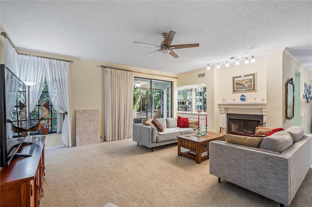 living room with rail lighting, a textured ceiling, light colored carpet, and ceiling fan