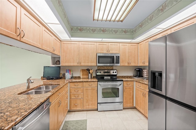 kitchen featuring light stone countertops, appliances with stainless steel finishes, and sink