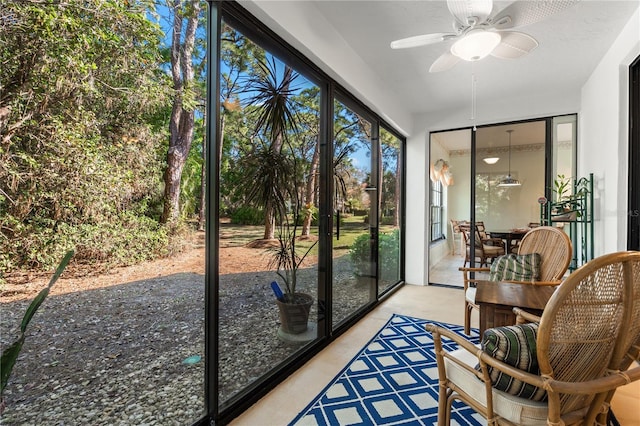 unfurnished sunroom with ceiling fan