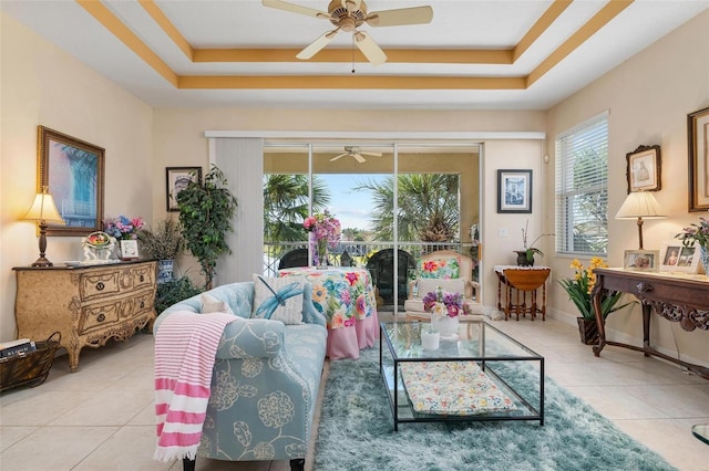 tiled living room featuring a raised ceiling and ceiling fan