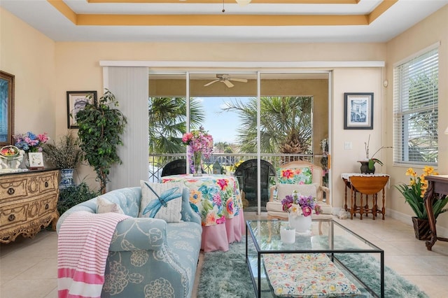 interior space with a raised ceiling and ceiling fan