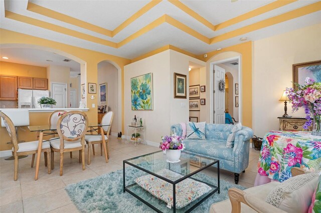 tiled living room featuring a tray ceiling